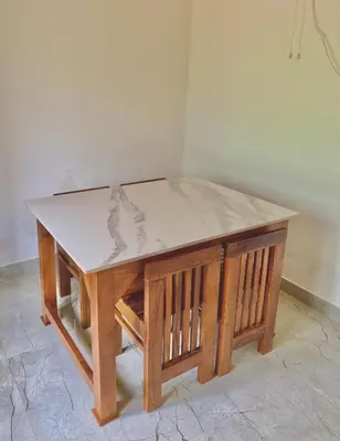 a wooden table with a marble top on top at GroveStay in Chakkarakkal
