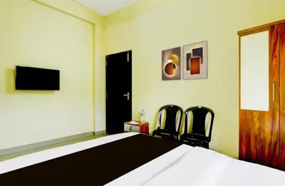 a bedroom with a bed and two chairs at RK Residency in Kozhikode