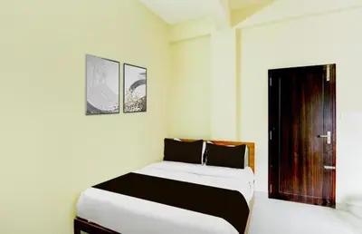 a bedroom with a white bed and a window at RK Residency in Kozhikode