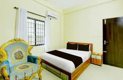 a bedroom with a bed and a chair at RK Residency in Kozhikode