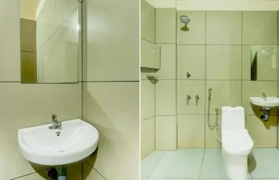 a white bathroom with a sink and a toilet at RK Residency in Kozhikode