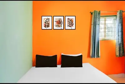 a bedroom with a bed with four pictures on the wall at Aryas comforts near Gumbaz in Shrīrangapattana