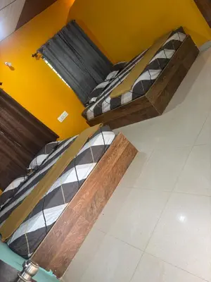 two beds in a room with a yellow wall at Aryas comforts near Gumbaz in Shrīrangapattana