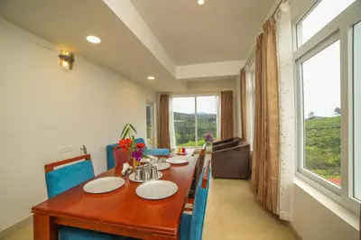 a dining room with a wooden table and a large window at Heavenly Hills 4 BHK Villa - 1 Bedroom in Kotagiri