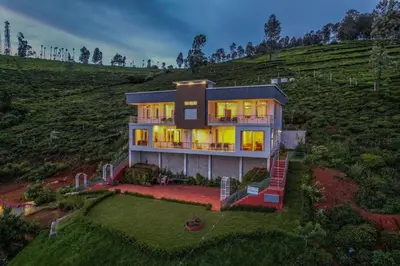 a house on a hill with its lights on at Heavenly Hills 4 BHK Villa - 1 Bedroom in Kotagiri
