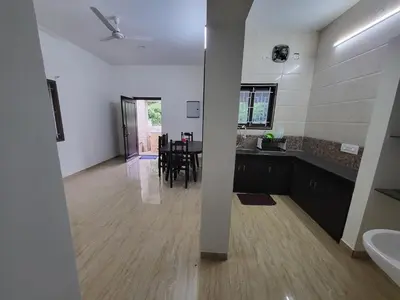 a living room with a kitchen and a dining room at Serene Steps in Coimbatore