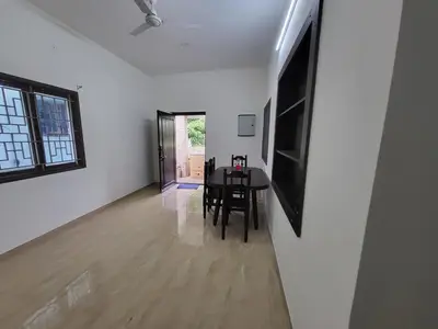 a dining room with a table and a television on a wall at Serene Steps in Coimbatore