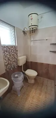 a bathroom with a toilet and a bidet and a sink at Hotel BMR Stay in Pollāchi