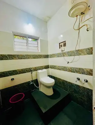 a bathroom with a white toilet and a sink at Quiet quarters Estate Stay in Napoklu