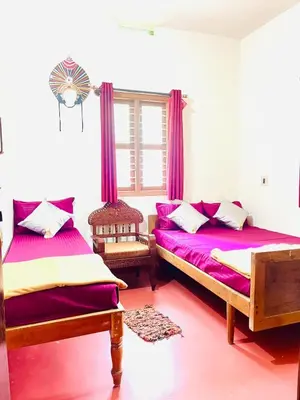 a bedroom with two beds and purple curtains at Quiet quarters Estate Stay in Napoklu