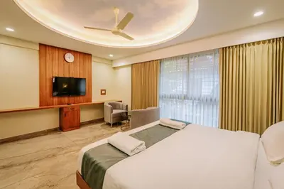 a hotel room with a bed and a tv at Hotel Urban Bella in Kozhikode
