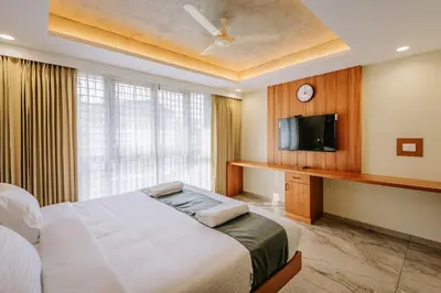 a bedroom with a bed and a flat screen tv at Hotel Urban Bella in Kozhikode