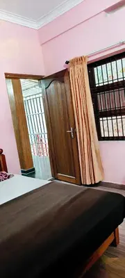a bedroom with a bed and a window with a curtain at Banasura Green paradise , Villa , Deluxe rooms , Budget rooms in Padinjarathara