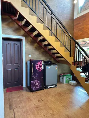 a stairway with a refrigerator next to a door at Cottage on Riverside in Irinjālakuda