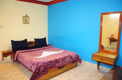 a bedroom with a bed with a mirror and a dresser at Hotel Zaraa in Ooty
