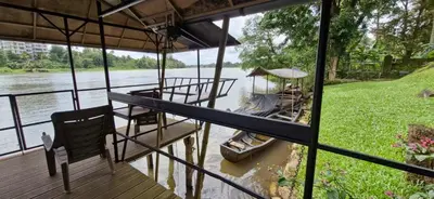 a house on a river with a boat in the water at Pearl Spot in Alwaye