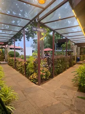 a pergola with a street sign in a garden at Suraksha Suites in Mysore