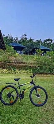 a bike parked on the grass in a field at Nature's nest in Kuttampuzha