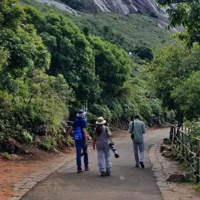 a group of people walking down a dirt road at Nature's nest in Kuttampuzha