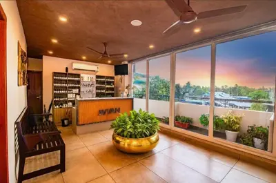 a room with a large window with plants in it at Neelagiri Heritage Hotel in Kozhikode