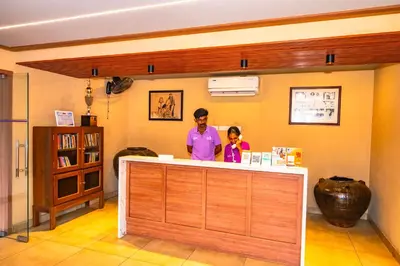 a man and a child standing at a counter in a room at Neelagiri Heritage Hotel in Kozhikode