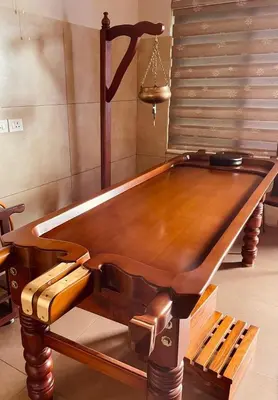a wooden pool table with a bench in a room at Neelagiri Heritage Hotel in Kozhikode
