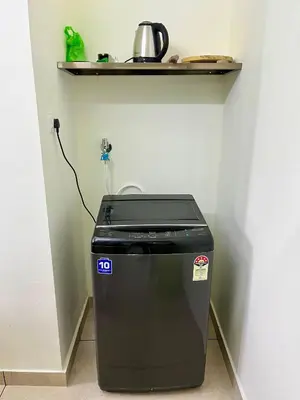 a trash can sitting next to a wall with a shelf at Ayat Apartments - near to Rajagiri Hospital in Alwaye