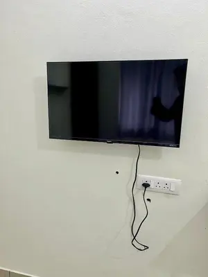 a flat screen tv hanging on a wall at Ayat Apartments - near to Rajagiri Hospital in Alwaye
