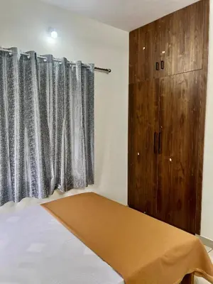 a bedroom with a bed and a window with curtains at Ayat Apartments - near to Rajagiri Hospital in Alwaye