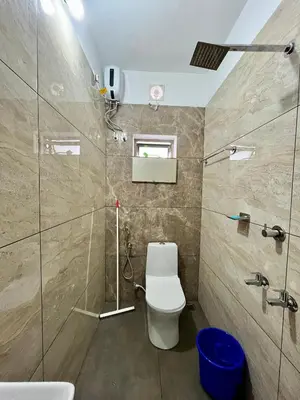 a bathroom with a toilet and a glass shower at Ayat Apartments - near to Rajagiri Hospital in Alwaye