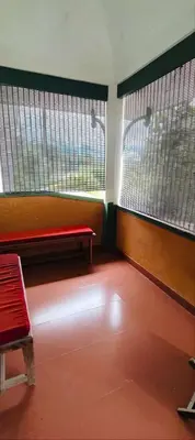 a waiting room with a red bench and two windows at Tejana villa in Mananthavady