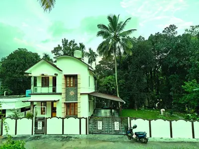 a house with a scooter parked in front of it at Full Home Wayanad Bathery in Sultan Bathery
