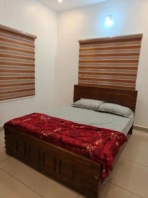 a bedroom with a wooden bed with red sheets at Full Home Wayanad Bathery in Sultan Bathery