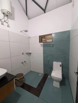 a bathroom with a toilet and a sink at Vayalil Homestay in Karuvārakundu