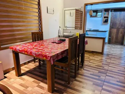 a kitchen with a table with a red table cloth at Vayalil Homestay in Karuvārakundu
