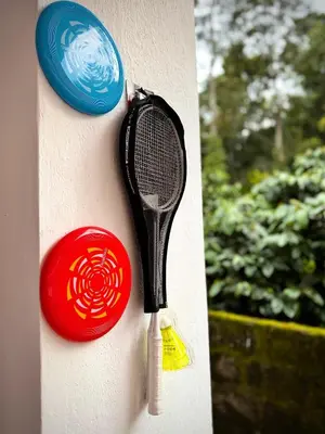 a tennis racket is hanging on a wall at Coorg Robusta Retreat in Suntikoppa