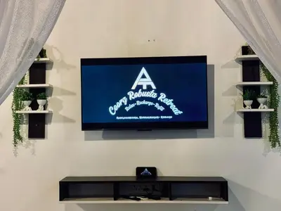 a flat screen tv on a white wall at Coorg Robusta Retreat in Suntikoppa