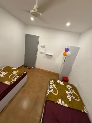 a room with two beds and a door in it at AAN GREENS Rooms And Dormitorys in Vaduvanchal