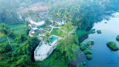 an aerial view of a house on a river at Pakalakam Resorts in Cheruppulasseri
