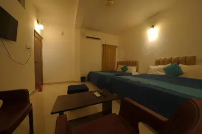 a hotel room with two beds and a table at Cozy retreat in Mysore