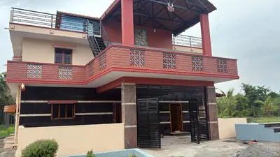 a house with a balcony on top of it at Lakshminarayanappa Niwasa in Channapatna
