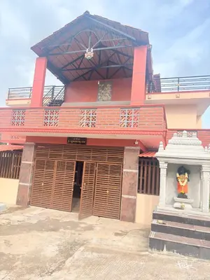 a large red building with a statue in front of it at Lakshminarayanappa Niwasa in Channapatna