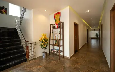 a hallway with stairs and a vase of flowers at Boulevard Premium Luxury Hotel in Munnar