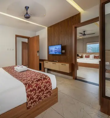 a hotel room with a bed and a tv at Boulevard Premium Luxury Hotel in Munnar