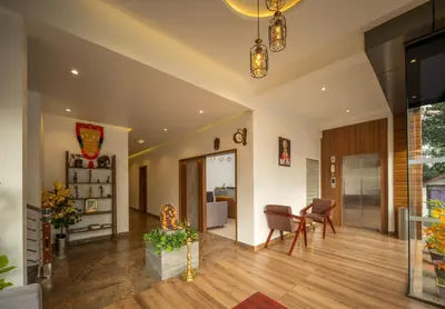 a living room with wooden floors and a dining room at Boulevard Premium Luxury Hotel in Munnar
