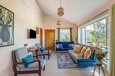 a living room with a couch and chairs at StayVista at Rustling Pine with Bonfire, BBQ & Lawn in Ooty