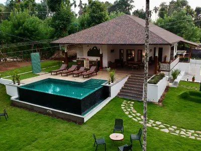 a house with a swimming pool in a yard at Tranquil Resort - Blusalzz Collection, Wayanad - Kerala in Ambalavayal