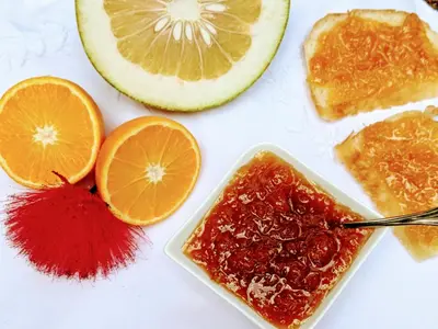 a table with orange slices and a bowl of jam at Tranquil Resort - Blusalzz Collection, Wayanad - Kerala in Ambalavayal