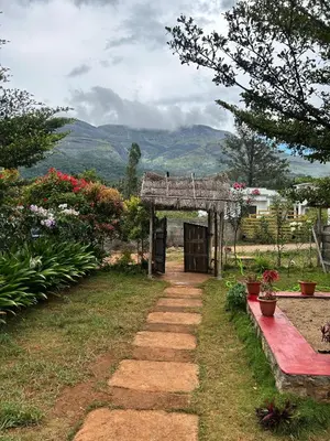 a garden with a small shed in the grass at Mannora Resorts Marayoor in Marayoor