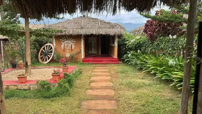 a small house with a red door and a wheel at Mannora Resorts Marayoor in Marayoor